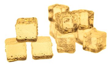 Golden ice cubes on white background.