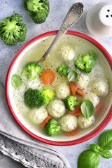Soup with chicken meatballs, rice, broccoli and green pea.Top view.