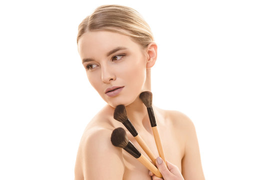 The cute girl with cosmetic brushes on the white background