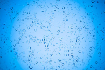 Rain droplets on blue glass background, Water drops on glass.
