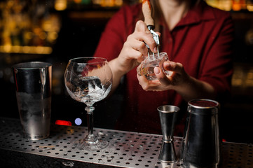 Female barman preparing ice cube for making cocktail