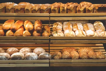 Gordijnen different fresh bread on the shelves in bakery © Наталья Маяк