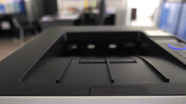 Laser print machine printing the documents in office with people hand
