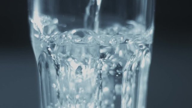 closeup slowmotion of glass fulling with water bubble floating