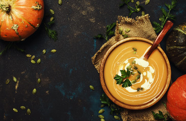 Cream pumpkin soup in a wooden bowl, rustic style, top view