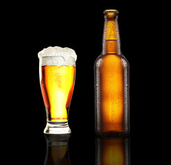 bottle and glass with fresh beer on the black background