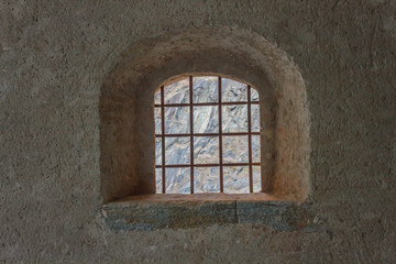 window with security grating of an ancient castle /detail of a window with wrought iron grating of an ancient castle