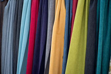 Tücher in bunten Farben hängen dicht nebeneinander