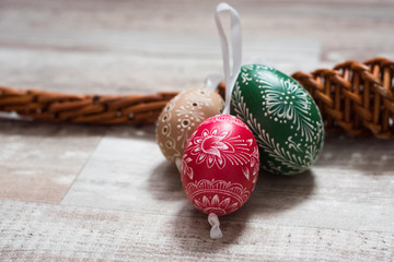 Obraz premium Homemade and handmade Easter eggs on birch branches on wooden tray, traditional czech, Easter egg hunt, whip with ribbons