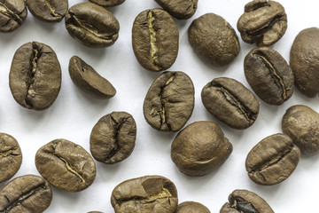 Roasted coffee beans. Different shapes and different shades of brown. On a white background. Photo for the site about food, drinks, health, business.