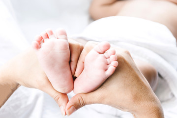 Fototapeta na wymiar Newborn baby feet on mother hands