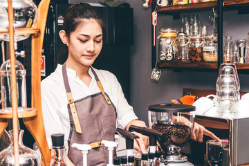 Women Barista using coffee machine for making coffee in the cafe