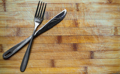 Silver Knife and fork on wooden table with copy space. top view