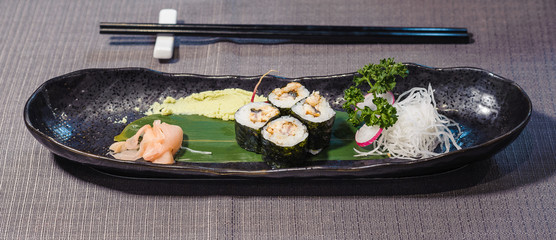 roasted eel sushi served on a bamboo leaf, with radishes, daikons, ginger gari and horseradish wasabi, fusion cousine