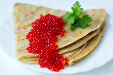 pancakes with caviar on a white plate