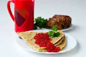 pancakes with caviar on a white plate
