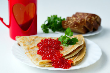 pancakes with caviar on a white plate
