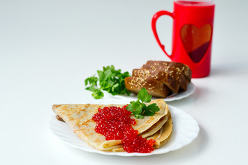 pancakes with caviar on a white plate