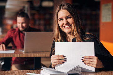 Fototapeta premium businesswoman with documents in her hands smiling at the camera