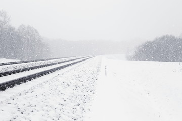Snowy railway in winter. Railroad in heavy snowfall.