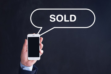 Hand Holding Smartphone with SOLD written speech bubble
