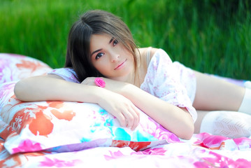 Obraz na płótnie Canvas Красивая девушка на кровати с цветами. Кровать на природе. Леди в белом платье на кровати в лесу. Красивый образ жизни. 