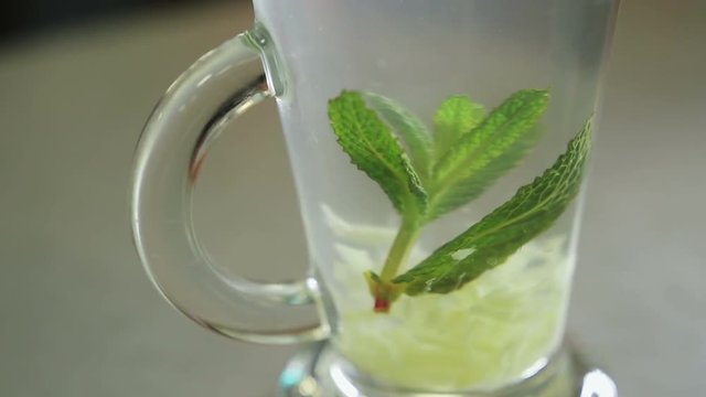 Mixing lemon, mint, ginger, water and sugar Close up