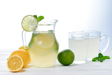 Citrus lemonade and lime water with lemon sliced , healthy and detox water drink in summer on white wooden table