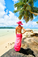 Woman tourist with sarong on tropical beach, mahe, seychelles