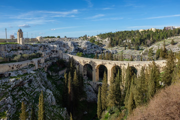 Canyon of Gravina with the old aqueduct stone bridge. Apulia region, Italy.