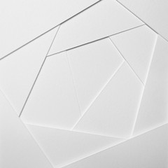 Abstract geometric background in light tones from sheets of thick white paper, cardboard.