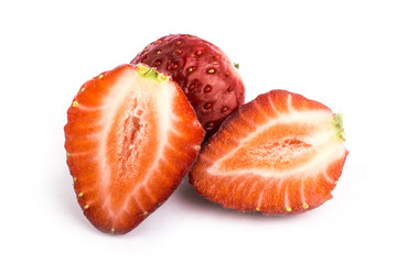 Isolated strawberries. Three fruits, one cut in half on white background
