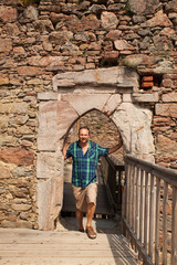Fototapeta na wymiar Mann steht in alter Stein Tür auf der Ruine Aggstein an der Donau