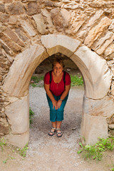 Fototapeta na wymiar Frau steht in alter Stein Tür auf der Ruine Aggstein an der Donau