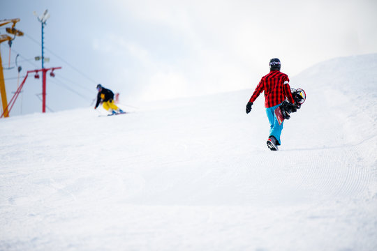 Photo of walking snowboarders in winter park