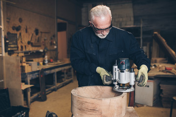 Senior master carpenter working in his woodwork or workshop.