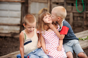 Girl from Italy came to visit her friends from Russia. One girl and two boys feed the pigs. One of...