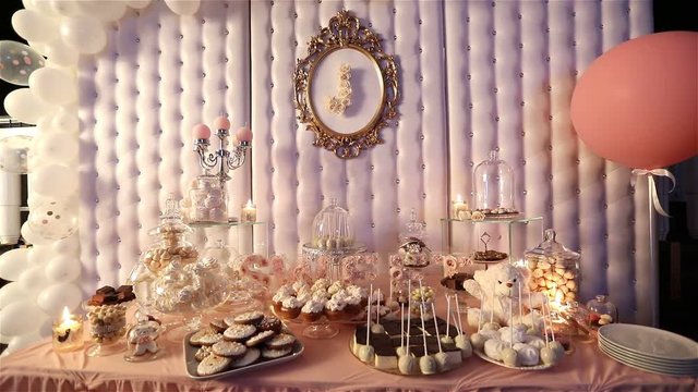 Candy bar in the restaurant, children's party, a white teddy bear with a butterfly on her neck, lit candle, teddy bear on a table Candy bar, close-up, Candy bar design, design Candy Bar