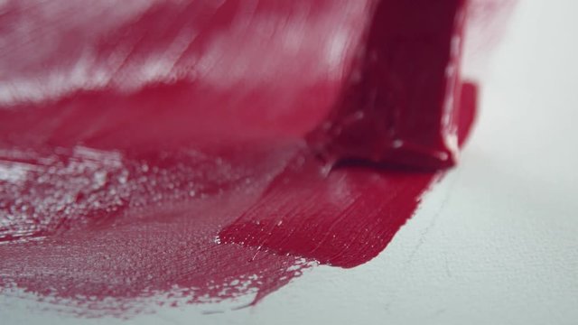 closeip macro of painting brush with red color acryl paint on white paper
