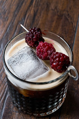 Black / Dark Beer Cocktail with Blackberries and Ice on Wooden Surface.