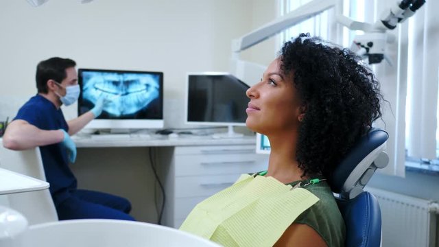 Man dentist showing x-ray results to his pacient.