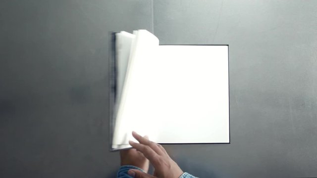 man turning pages of book, magazine with empty white pages