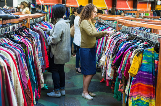Women browsing through vintage clothing in a Thrift Store.