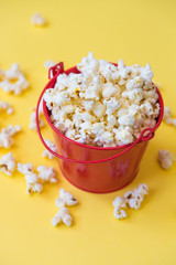 popcorn in a red bucket on a yellow background