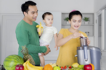 Young family making healthy juice at home
