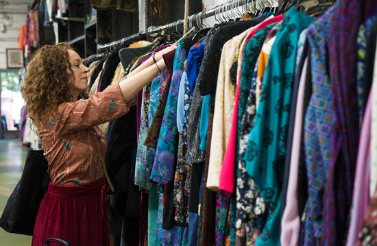 Woman browsing through vintage clothing in a Thrift Store.