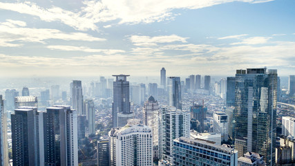 Obraz premium Panoramę Dżakarty z nowoczesnymi biurowcami i apartamentami w słoneczny dzień