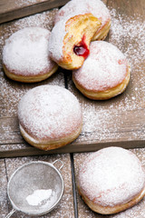 Traditional Polish donuts on wooden background.  Tasty doughnuts with jam.