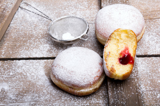 Traditional Polish donuts on wooden background.  Tasty doughnuts with jam.