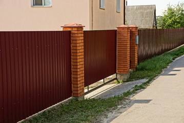 Metal fence of red color near the road